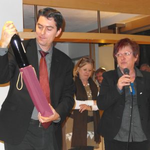 Uta Böckel überreicht Dr. Sascha Raabe eine Flasche Wein